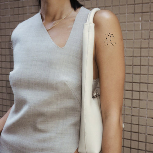An individual wearing a daily defense vitamin patch on their arm.