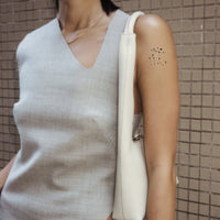 An individual wearing a daily defense vitamin patch on their arm.