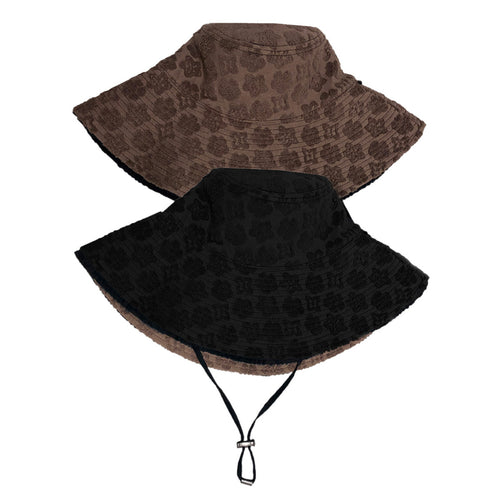 A comparison of the two sides of a sun hat. One side is black with an adjustable strap, and the other side is brown. Both items are placed on a light grey background.
