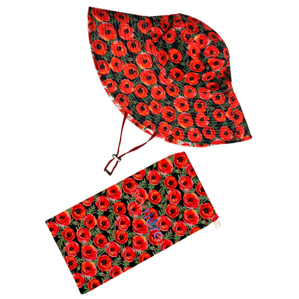 A sun hat with a red floral pattern and a matching pouch beside it, featuring bright red poppies with black details on a dark background.