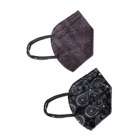 A collection of five face masks laid out on a light gray background. There are two distinct designs: three masks feature a paisley pattern with a black base and white intricate designs, while two masks are in a solid black shade.
