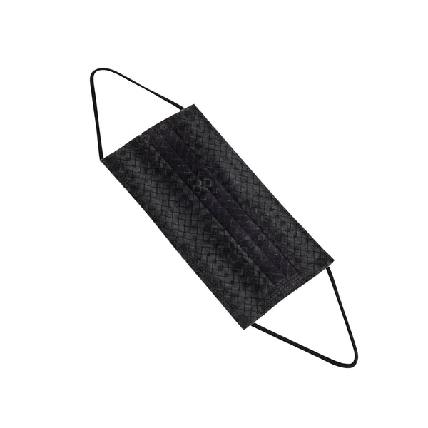 A single black face mask with ear loops lying on a white surface. The mask is designed for personal protection.