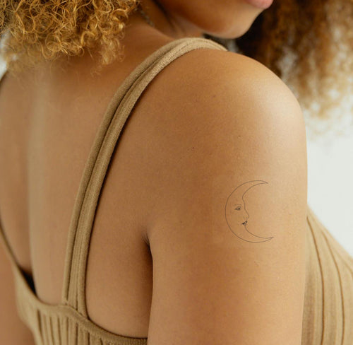 An individual wearing a black 'Daily Defense' patch on their arm featuring a crescent moon.