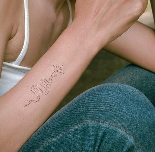 An individual wearing a black 'Daily Defense' patch on their forearm, featuring snake.