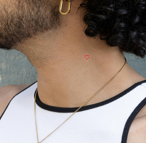 An individual wearing an 'ENERGY BOOST' vitamin patch on their neck from a side angle featuring a red heart.