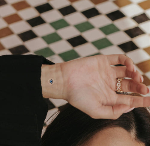An individual with an ‘ENERGY BOOST’ vitamin patch stuck on their inner wrist featuring small blue eye.