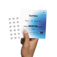 Someone holding the packaging of Barriere’s ‘CALL OF BEAUTY’ vitamins. The packaging is white with a blue gradient emerging from the bottom right corner, featuring various shades of blue. The package contains 36 patches, some of which are visible in the photo.