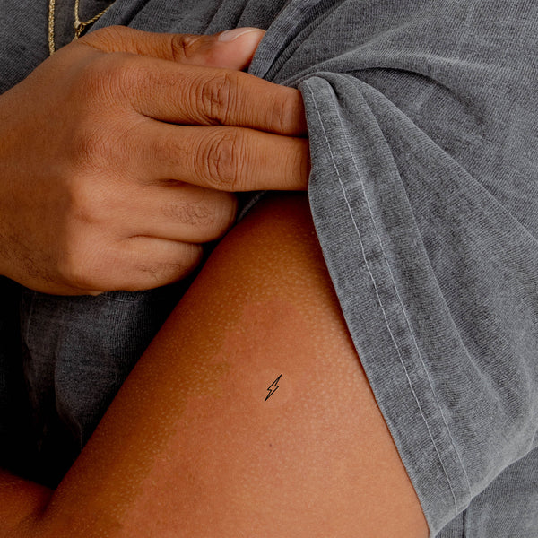 Close up of an individual with an ‘ENERGY BOOST’ vitamin patch stuck on their arm.