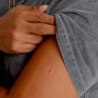 Close up of an individual with an ‘ENERGY BOOST’ vitamin patch stuck on their arm.