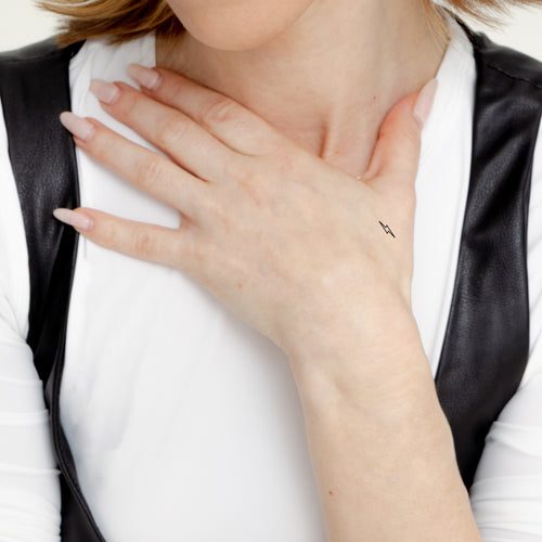 An individual with an ‘ENERGY BOOST’ vitamin patch stuck on their hand.