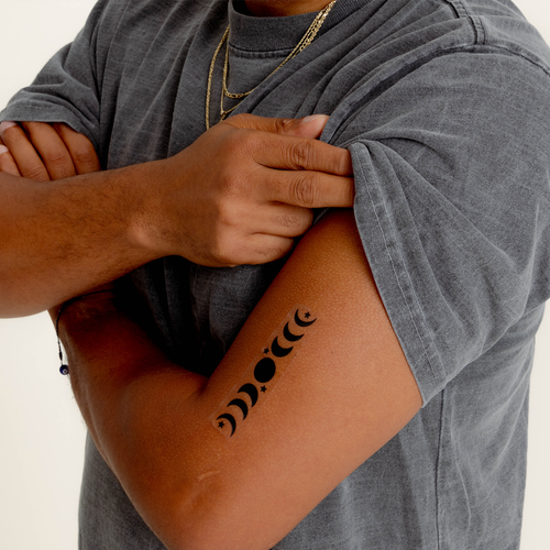 A  vitamin patch featuring a four phases of the moon in a vertical alignment on their arm.