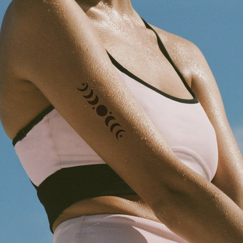 A  vitamin patch featuring a four phases of the moon in a vertical alignment on the upper arm. 