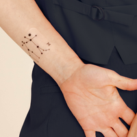 An individual wearing a daily defense vitamin patch on their wrist.
