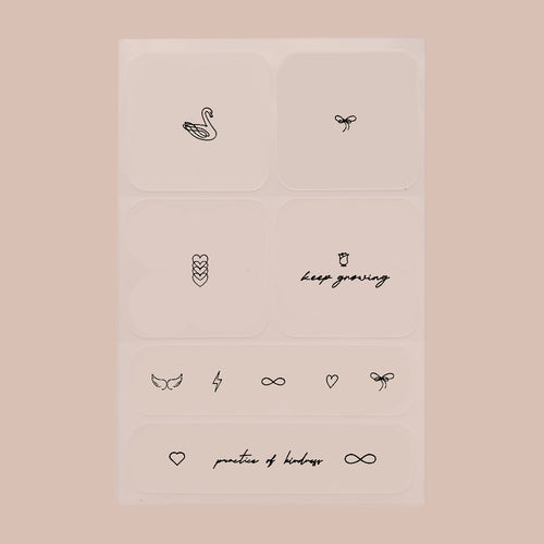 Six black patches with small prints on each, featuring designs ranging from swans to hearts to quotes, on a beige background.