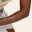 A BRAINS AND BEAUTY patch in gold places on the arm.