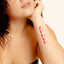  Close-up of an individual’s  forearm adorned with a four strip vitamin patch of cherries, arranged in a vertical line.