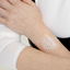 An individual wearing a white “DAILY DEFENSE PATCH” on their arm.