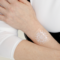 An individual wearing a white “DAILY DEFENSE PATCH” on their forearm. The patch features a flower-like image.